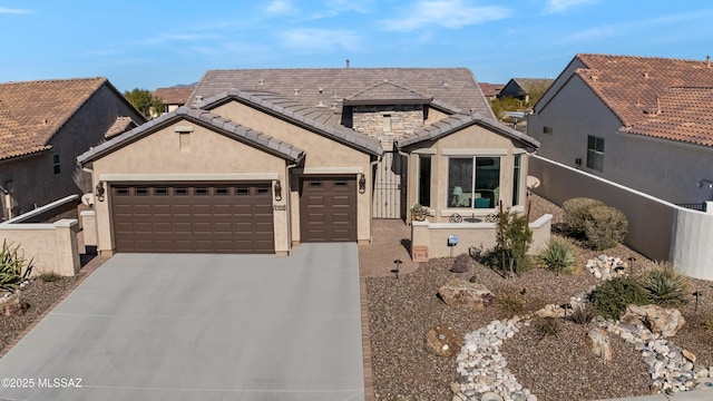view of front of house featuring driveway, a tiled roof, fence, a garage, and stucco siding