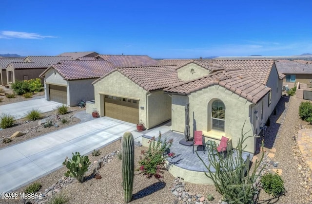 mediterranean / spanish-style home featuring a garage, a tile roof, driveway, and stucco siding