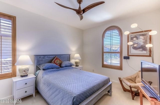 bedroom with light carpet, a ceiling fan, and baseboards