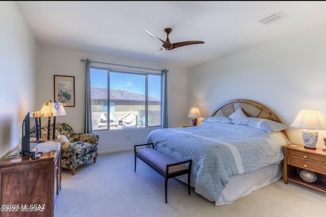 carpeted bedroom featuring a ceiling fan and visible vents