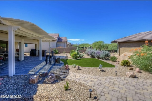 view of yard with a patio area, a fenced backyard, and a pergola