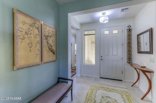 tiled foyer featuring baseboards and visible vents