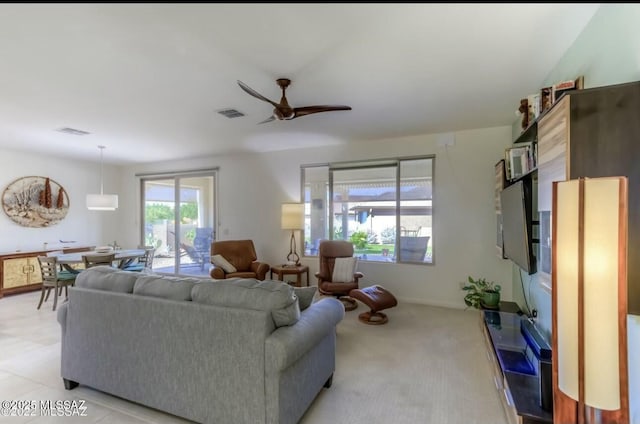 living area featuring visible vents, a ceiling fan, and light colored carpet