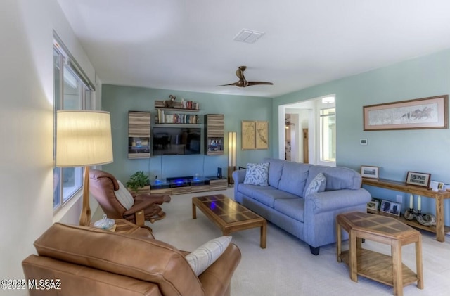 carpeted living area featuring a ceiling fan and visible vents