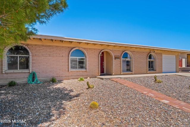 9061 E 39th St, Tucson, AZ 85730 - ranch-style home with brick siding, a garage, and concrete driveway