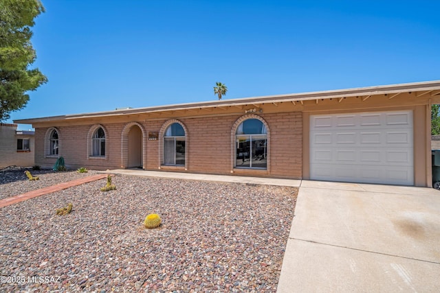 9061 E 39th St, Tucson, AZ 85730 - ranch-style home with brick siding, a garage, and driveway