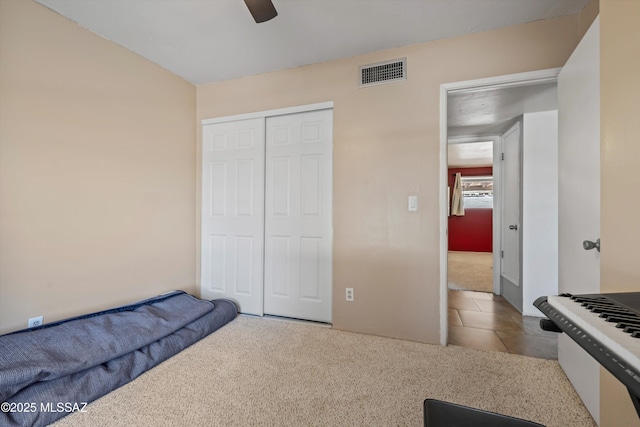 9061 E 39th St, Tucson, AZ 85730 - carpeted bedroom featuring tile patterned floors, a ceiling fan, a closet, and visible vents