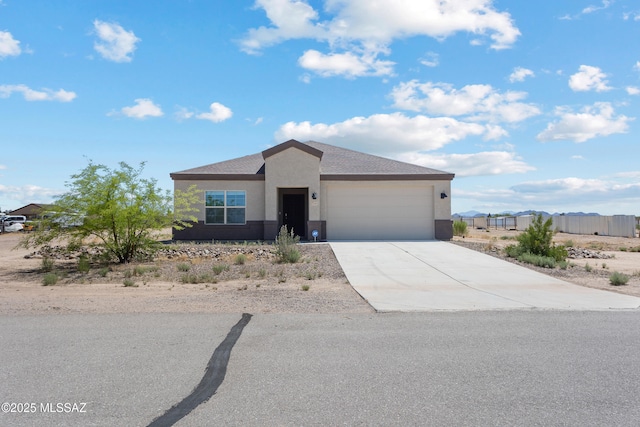 ranch-style house featuring a garage, driveway, and stucco siding