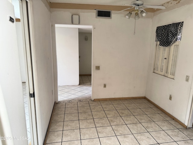 spare room with a ceiling fan, visible vents, and light tile patterned floors
