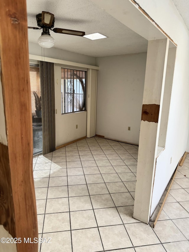 unfurnished room with a ceiling fan and light tile patterned floors