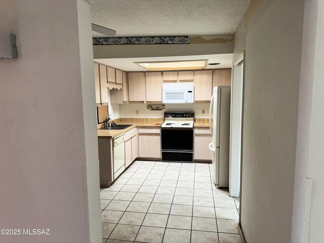 kitchen with light brown cabinets, a sink, white appliances, light tile patterned floors, and light countertops