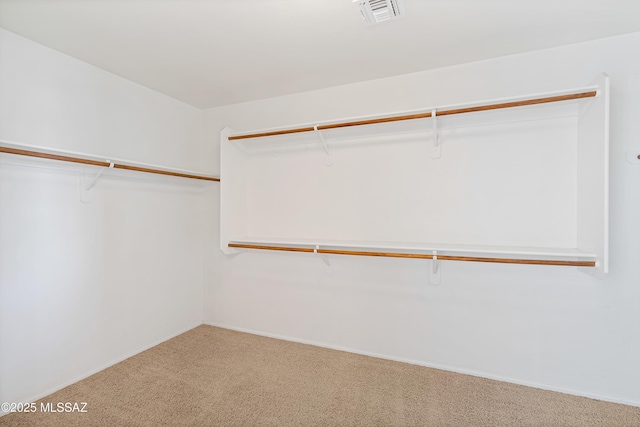 walk in closet featuring visible vents and carpet floors
