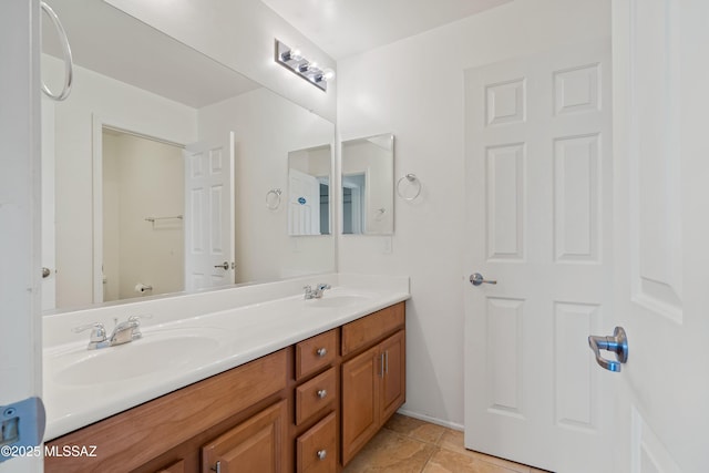 full bathroom featuring double vanity, toilet, baseboards, and a sink
