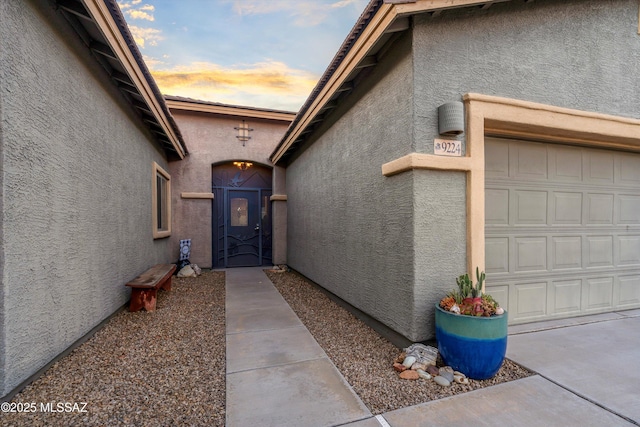 9224 S Big Tree Ln, Tucson, AZ 85756 - view of exterior entry featuring stucco siding, a gate, and a garage