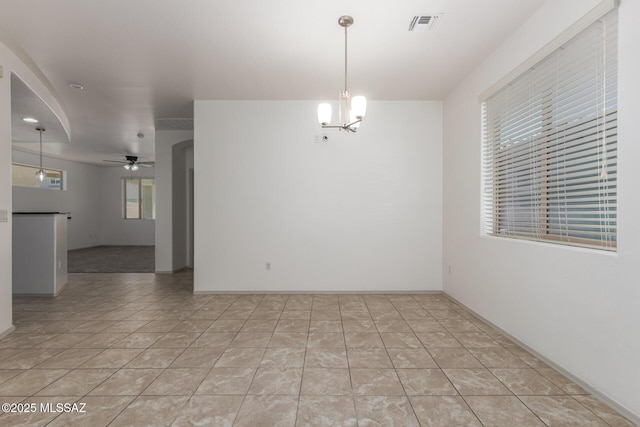 empty room with visible vents, ceiling fan with notable chandelier, and light tile patterned flooring