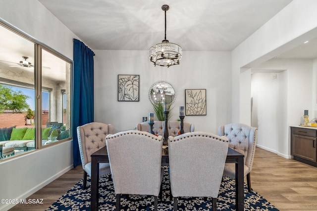 dining area with light wood finished floors, baseboards, and ceiling fan with notable chandelier
