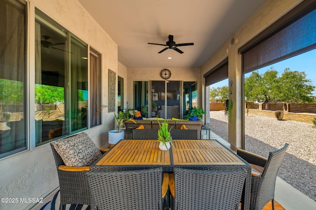 view of patio with outdoor dining area, fence, and a ceiling fan
