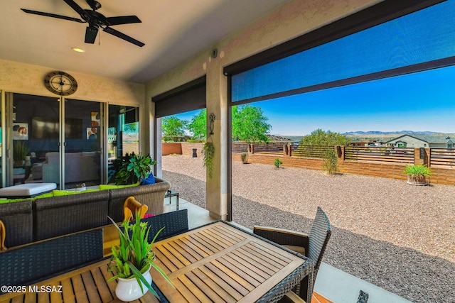 view of patio / terrace with a fenced backyard, a mountain view, ceiling fan, and an outdoor hangout area