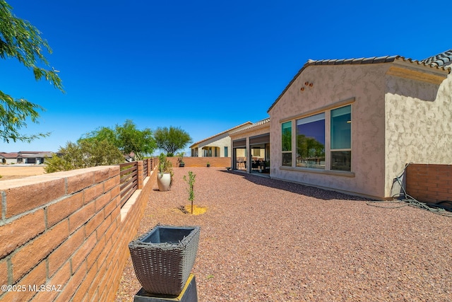 view of side of property with fence and stucco siding
