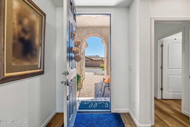 foyer featuring wood finished floors and baseboards