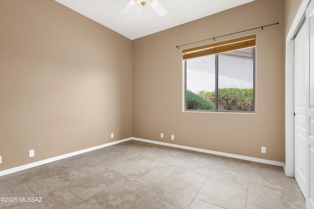 empty room featuring a ceiling fan and baseboards