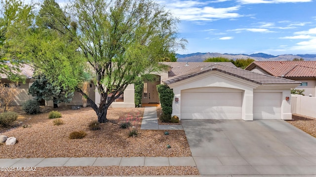 view of front of property featuring a garage, a mountain view, stucco siding, and concrete driveway