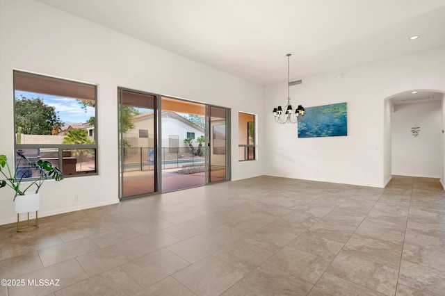 empty room with visible vents, baseboards, an inviting chandelier, arched walkways, and recessed lighting