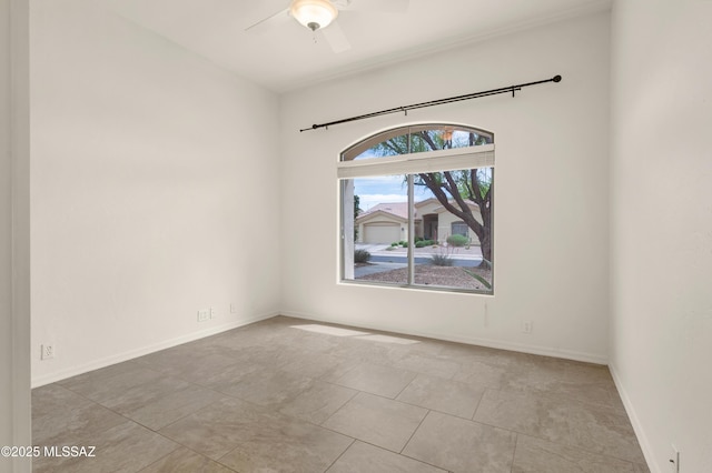 tiled spare room featuring ceiling fan and baseboards