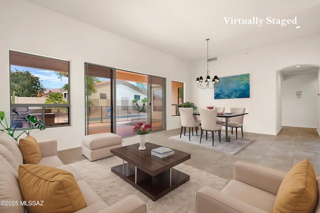 living area with a chandelier, visible vents, and arched walkways