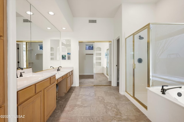 full bathroom with double vanity, visible vents, a stall shower, and a sink