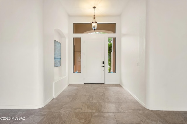 entrance foyer with baseboards and arched walkways