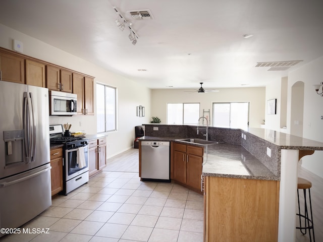 kitchen featuring a sink, a kitchen breakfast bar, stainless steel appliances, and visible vents