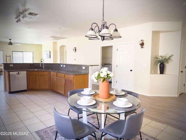 dining area featuring visible vents, arched walkways, ceiling fan with notable chandelier, and light tile patterned flooring
