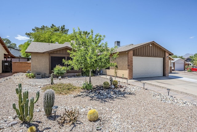 view of front of property with a chimney, board and batten siding, driveway, fence, and a garage