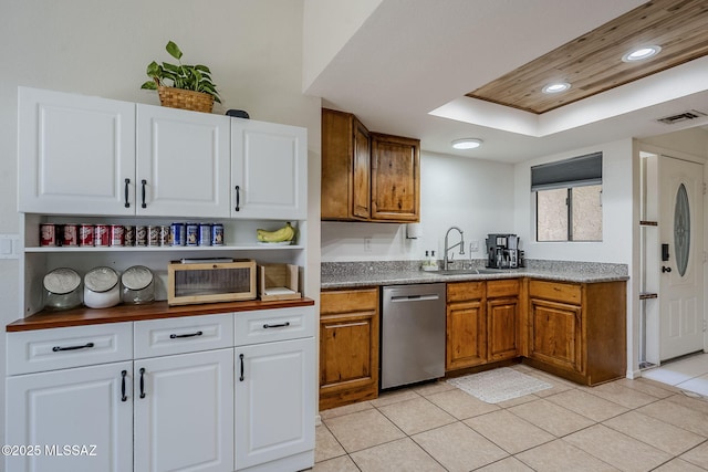kitchen with a sink, visible vents, dishwasher, white cabinetry, and light tile patterned floors