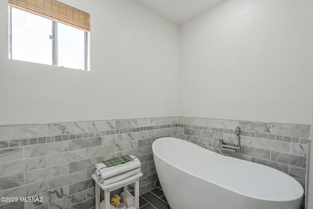 full bathroom featuring tile walls and a soaking tub