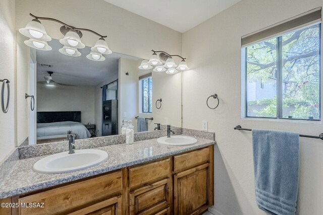 bathroom with ensuite bath, a healthy amount of sunlight, and a sink