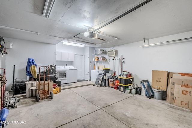 garage with independent washer and dryer, a garage door opener, and an AC wall unit
