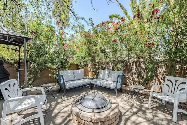 view of patio / terrace with an outdoor living space with a fire pit and a fenced backyard