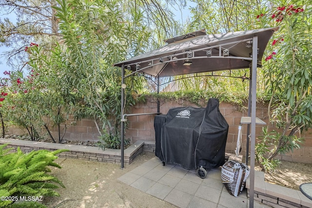 view of patio / terrace with grilling area, fence, and a gazebo