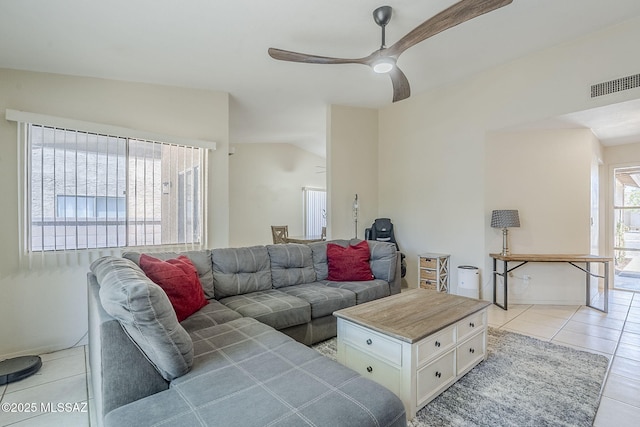 living room with a ceiling fan, baseboards, visible vents, light tile patterned flooring, and vaulted ceiling