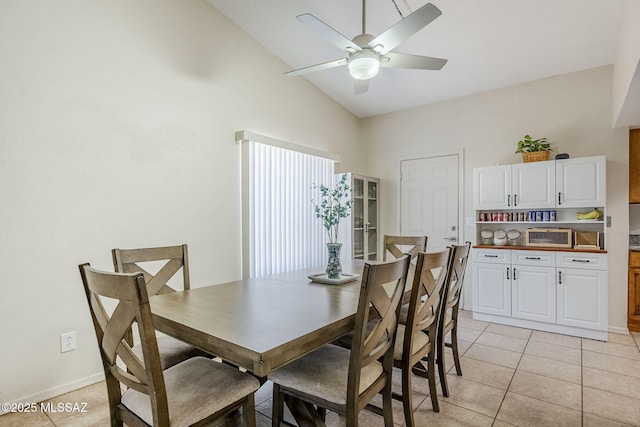 dining area with vaulted ceiling, light tile patterned flooring, baseboards, and a ceiling fan