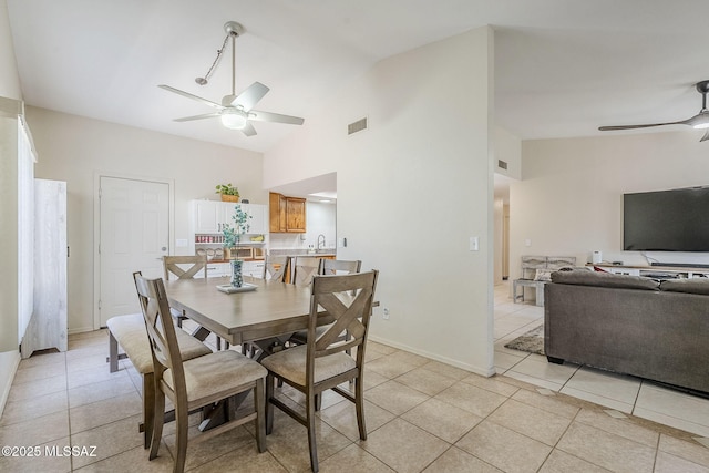 dining room with a ceiling fan, visible vents, light tile patterned flooring, and high vaulted ceiling