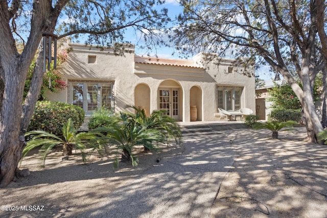 mediterranean / spanish-style home with a tile roof and stucco siding
