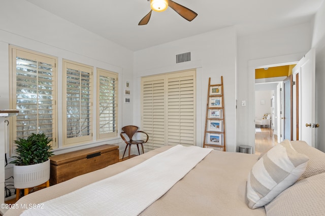 bedroom with visible vents, a ceiling fan, and a closet