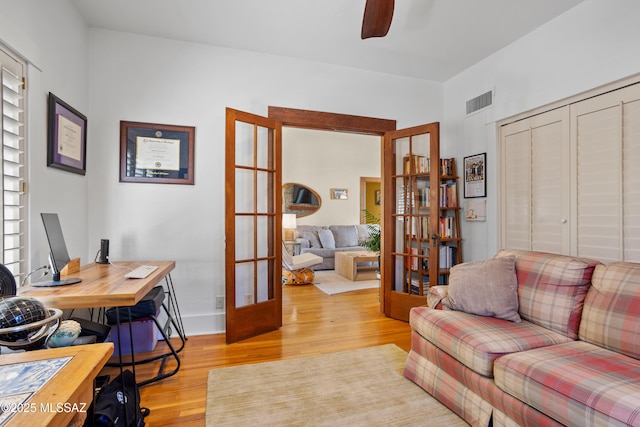 home office with a ceiling fan, visible vents, french doors, and light wood-type flooring