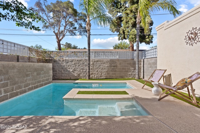 pool with a jacuzzi and a fenced backyard