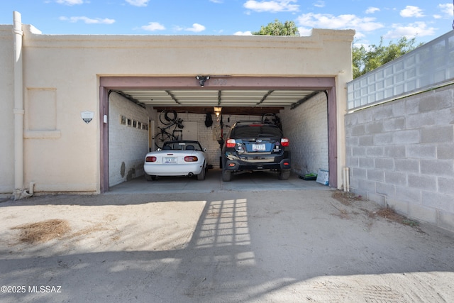 view of car parking with a garage and concrete driveway