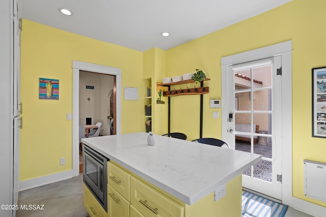 2733 E 6th St, Tucson, AZ 85716 - kitchen featuring stainless steel microwave, a kitchen island, recessed lighting, light stone counters, and finished concrete flooring