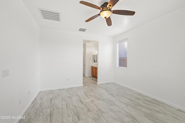 spare room with visible vents, ceiling fan, and baseboards